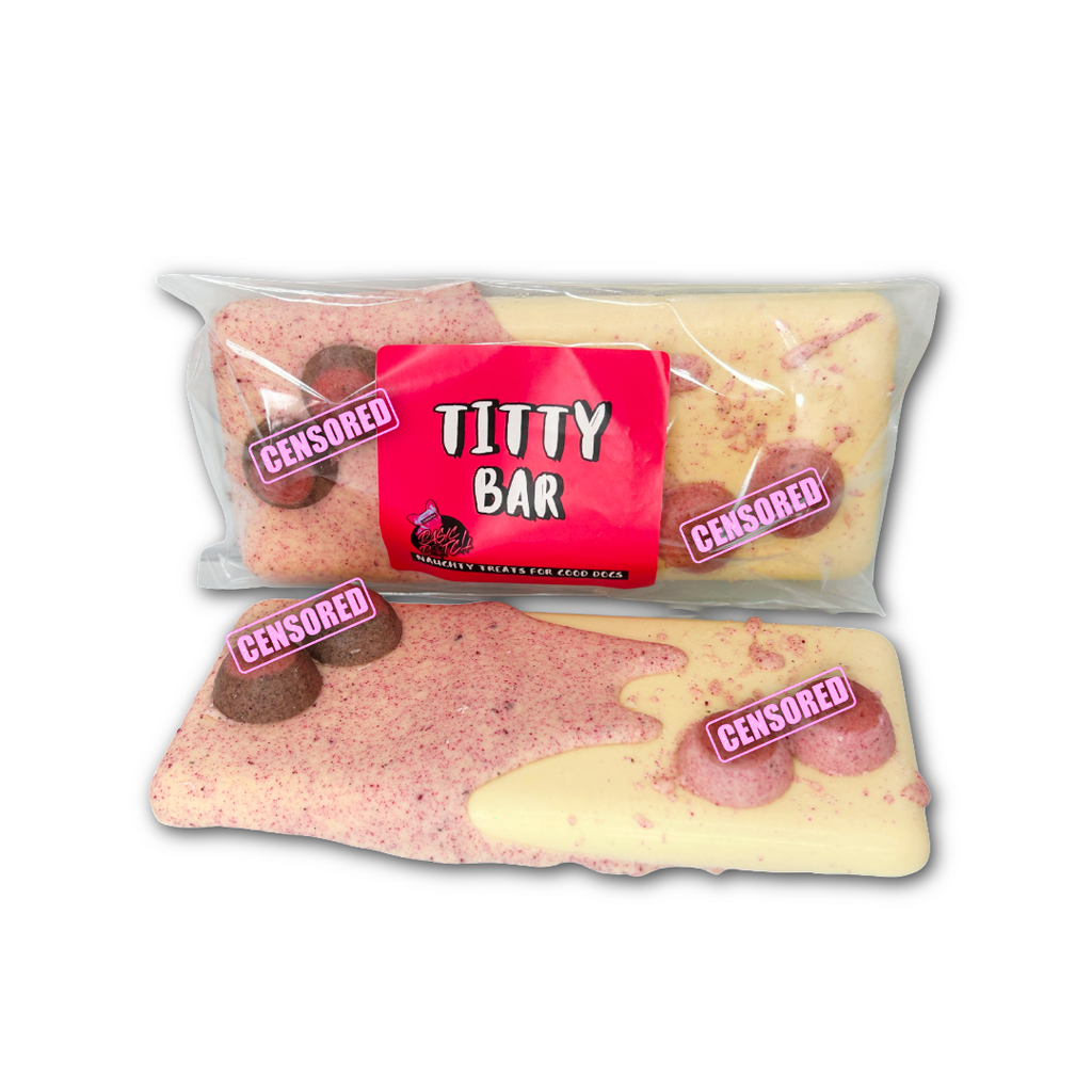 One package of a product labeled 'Titty Bar' in white writing on a pink sticker. An unwrapped white chocolate bar with pink chocolate dripping on one end, and splatters on the other. Brown boobs in top right corner and pink boobs in bottom left corner. On a white background. 